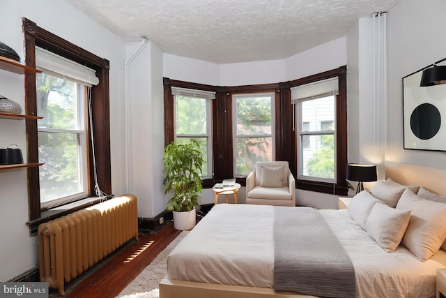 4505 Chester Ave, Philadelphia, PA 19143 - bedroom featuring radiator heating unit, wood finished floors, and a textured ceiling
