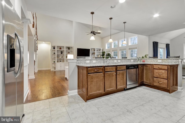 kitchen featuring open floor plan, ceiling fan, appliances with stainless steel finishes, brown cabinetry, and high vaulted ceiling
