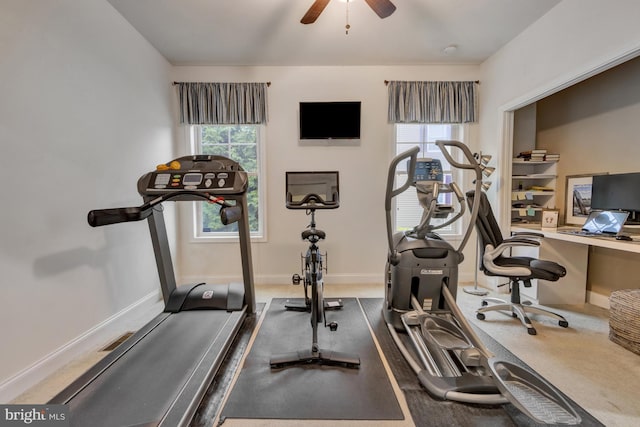 workout room with baseboards and a ceiling fan