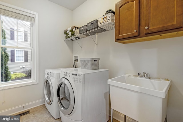 laundry area featuring washer and dryer, a sink, visible vents, and plenty of natural light