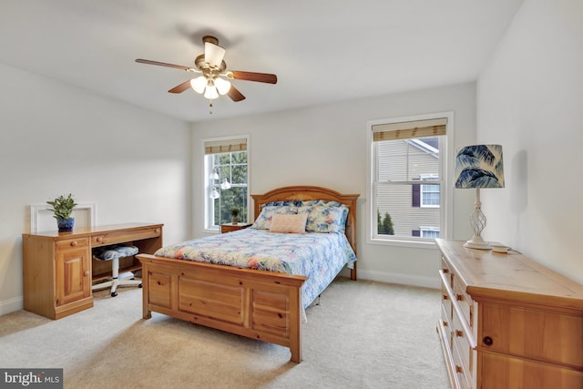 bedroom with light colored carpet, baseboards, and ceiling fan