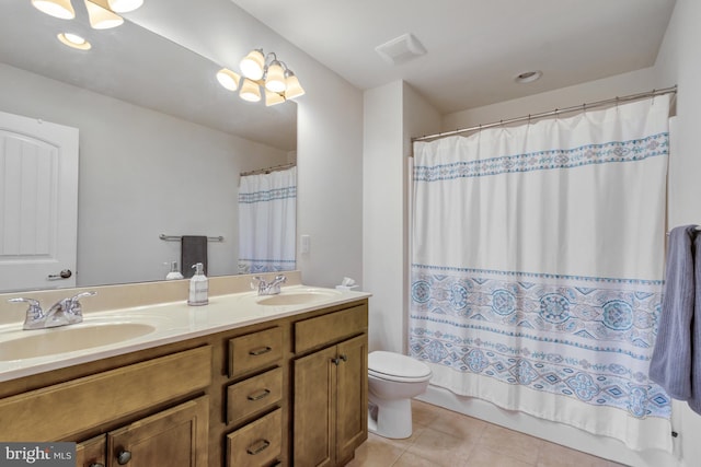 full bathroom with toilet, tile patterned floors, double vanity, and a sink