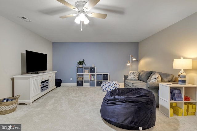 carpeted living area with visible vents, baseboards, and ceiling fan