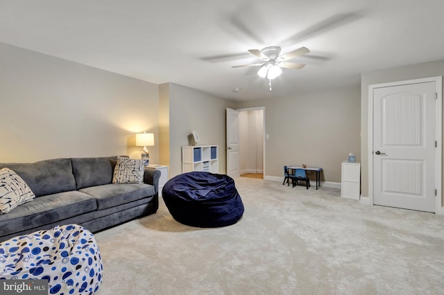 living room with carpet, baseboards, and ceiling fan