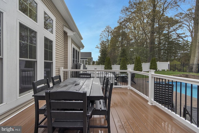 deck featuring a fenced backyard, outdoor dining space, and a fenced in pool