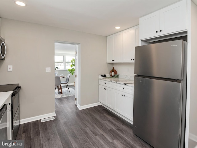 kitchen with stainless steel appliances, visible vents, baseboards, white cabinetry, and dark wood-style floors