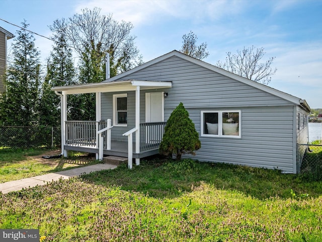 bungalow featuring a front lawn, fence, and a porch