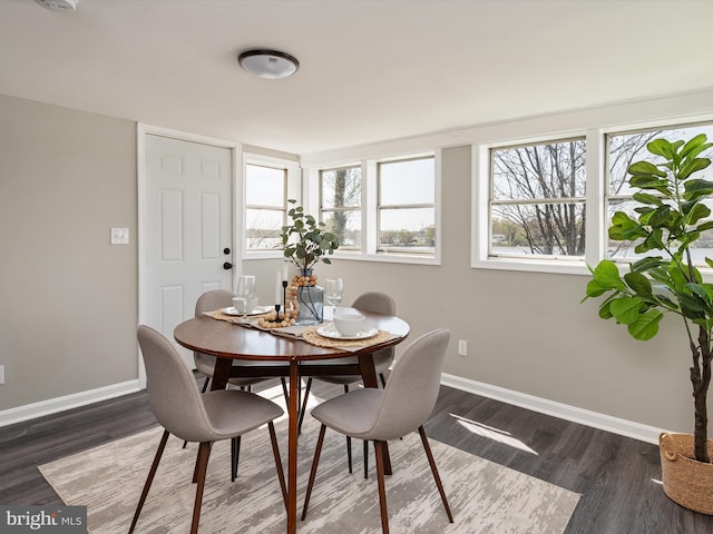dining area with baseboards and dark wood-type flooring