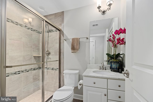 bathroom with toilet, visible vents, a shower stall, and vanity