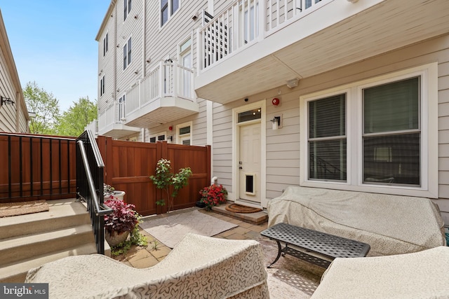 entrance to property featuring a patio and fence