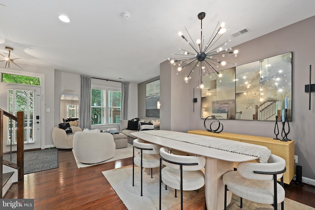 dining room featuring a chandelier, stairway, wood finished floors, and a healthy amount of sunlight