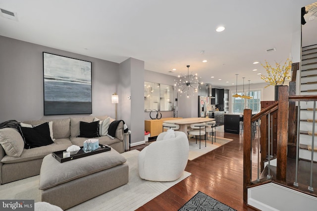 living area with dark wood-style floors, recessed lighting, a chandelier, stairs, and visible vents