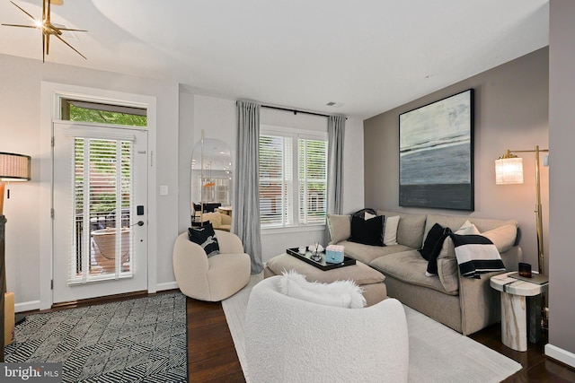 living room featuring dark wood-type flooring, a wealth of natural light, and baseboards