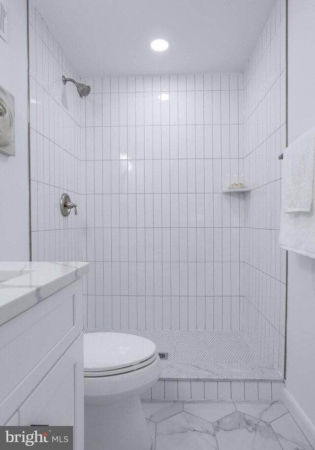 full bath with vanity, marble finish floor, tiled shower, and toilet