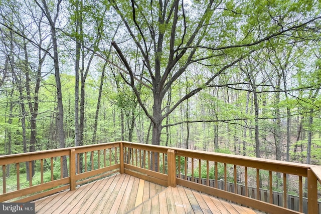 wooden deck with a wooded view