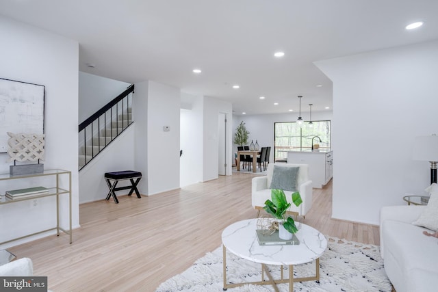living room featuring recessed lighting, stairway, and light wood finished floors