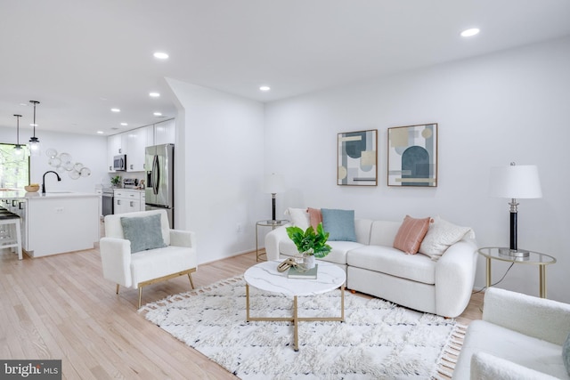 living area with recessed lighting and light wood-style floors