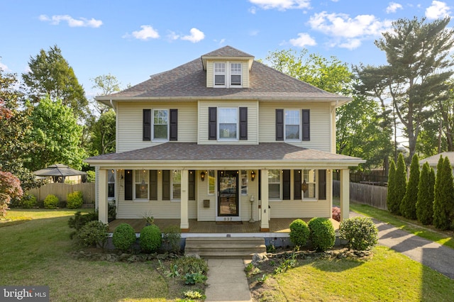 view of front of home featuring a porch, a shingled roof, fence, and a front yard