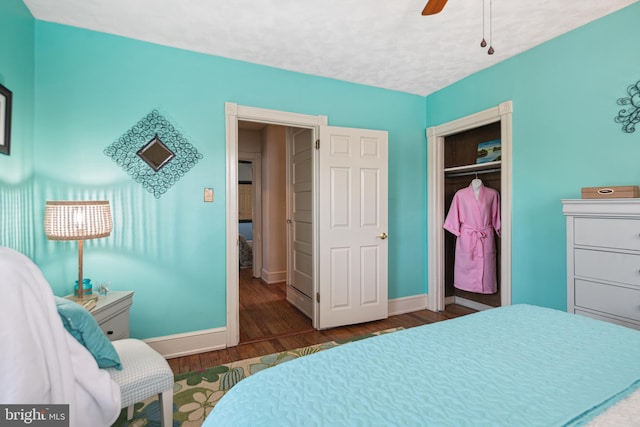 bedroom with baseboards, a ceiling fan, a closet, and wood finished floors