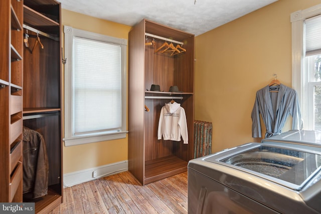 laundry room featuring laundry area, washer / dryer, baseboards, and hardwood / wood-style flooring