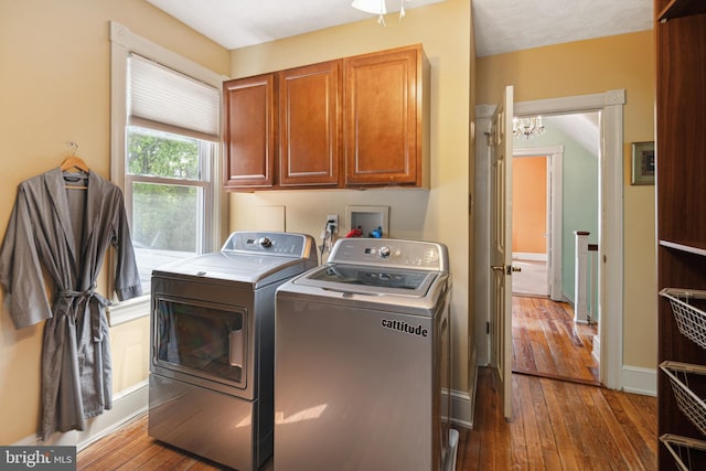 washroom featuring cabinet space, an inviting chandelier, baseboards, washer and clothes dryer, and hardwood / wood-style flooring