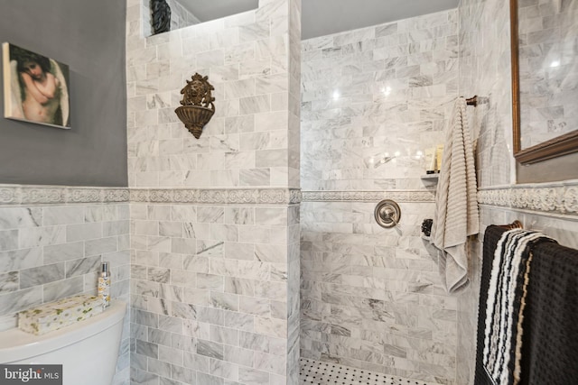 full bath with tile walls, a tile shower, and toilet