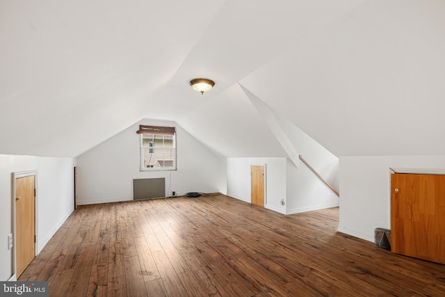 bonus room with baseboards, wood-type flooring, and vaulted ceiling