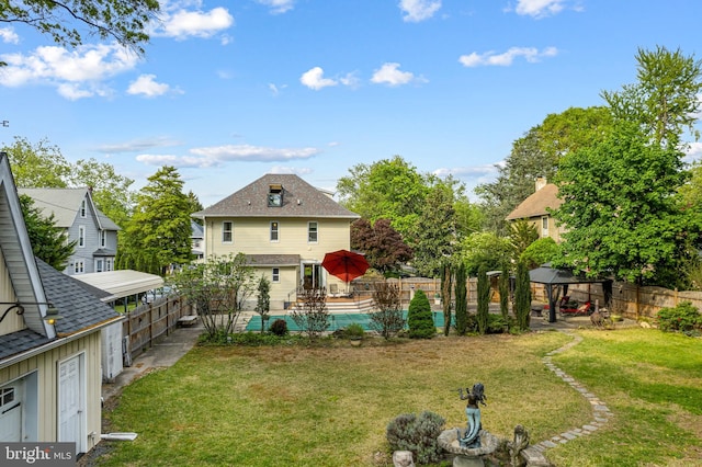 rear view of property with a lawn, a gazebo, and a fenced backyard