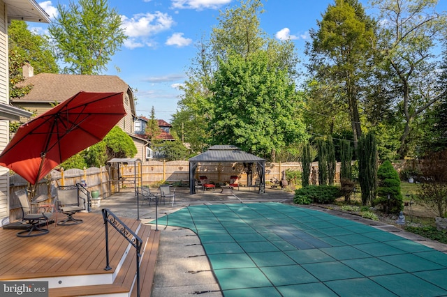 view of swimming pool featuring a deck, a patio area, a gazebo, a fenced in pool, and a fenced backyard