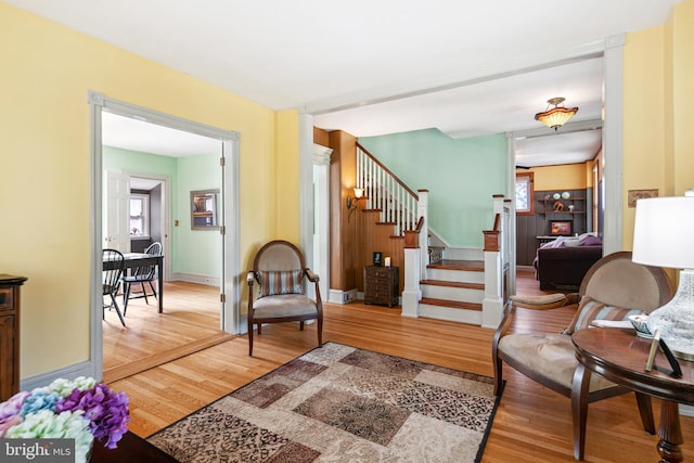 living room with baseboards, wood finished floors, and stairway