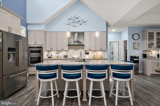 14626 Blue Heron Dr, Ocean View, DE 19970 - kitchen with stainless steel appliances, wall chimney range hood, tasteful backsplash, a sink, and a center island with sink