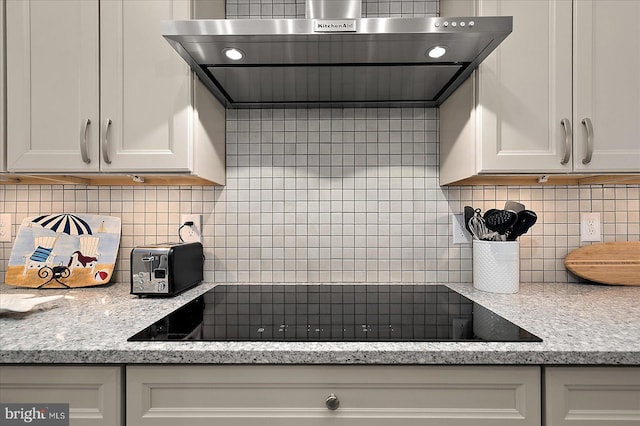 14626 Blue Heron Dr, Ocean View, DE 19970 - kitchen with exhaust hood, tasteful backsplash, black electric cooktop, and white cabinetry