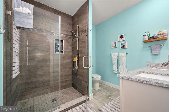 14626 Blue Heron Dr, Ocean View, DE 19970 - full bathroom featuring vanity, a shower stall, toilet, tile patterned floors, and baseboards