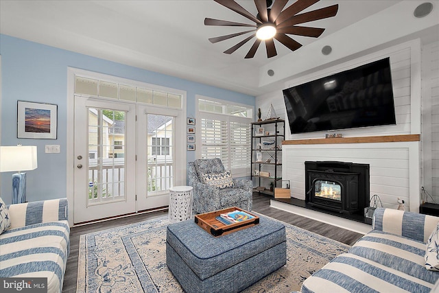 14626 Blue Heron Dr, Ocean View, DE 19970 - living area with a ceiling fan, wood finished floors, a warm lit fireplace, and a tray ceiling