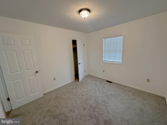 unfurnished bedroom with baseboards, visible vents, and carpet floors