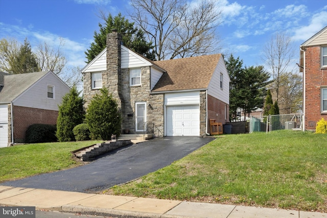 510 W S Ave, Glenolden, PA 19036 - traditional home featuring a chimney, aphalt driveway, fence, stone siding, and roof with shingles