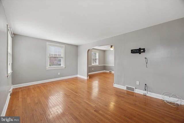 510 W S Ave, Glenolden, PA 19036 - unfurnished room with visible vents, arched walkways, light wood-style floors, baseboards, and ceiling fan