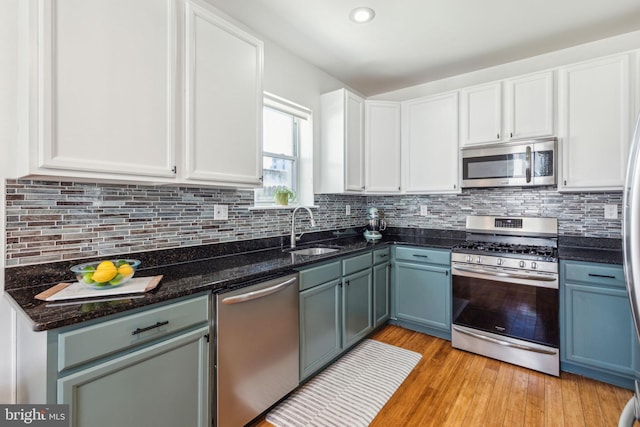kitchen featuring a sink, white cabinetry, appliances with stainless steel finishes, and backsplash