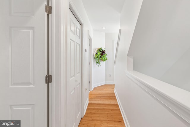 hallway with baseboards, recessed lighting, and light wood finished floors