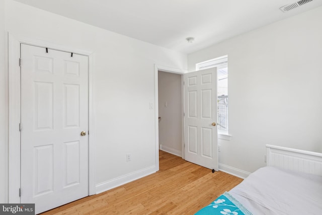 bedroom with baseboards, visible vents, and light wood-style floors