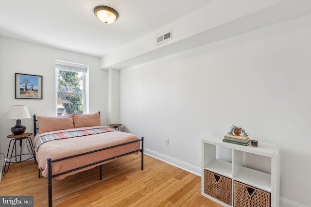 bedroom featuring light wood-style floors, baseboards, and visible vents