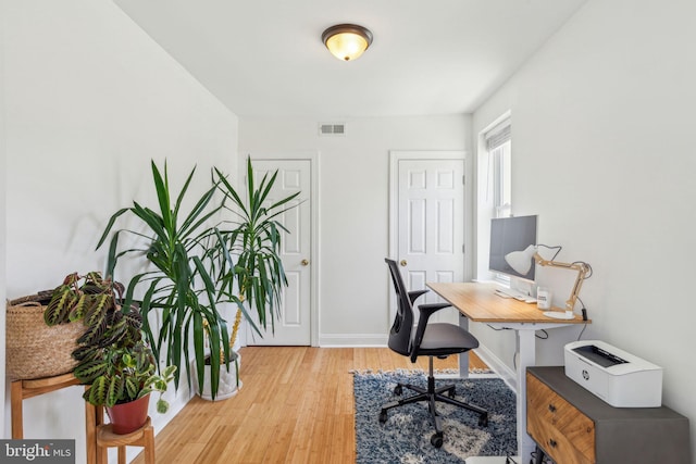 office featuring baseboards, wood finished floors, and visible vents