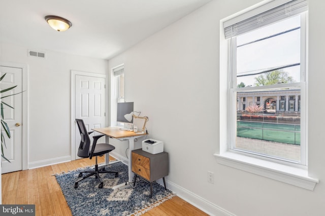 office with baseboards, light wood-style flooring, and visible vents