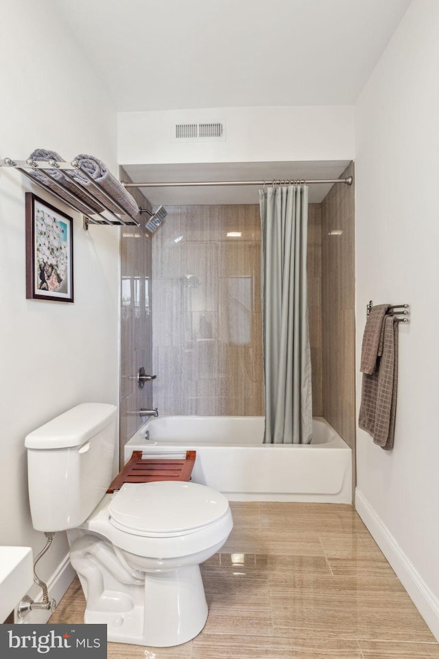 full bath featuring baseboards, shower / bath combo with shower curtain, toilet, and visible vents