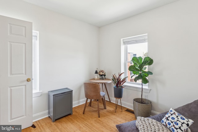 sitting room featuring baseboards and light wood-style floors