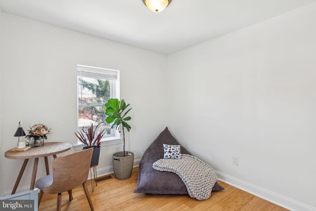 living area with baseboards, wood finished floors, and visible vents