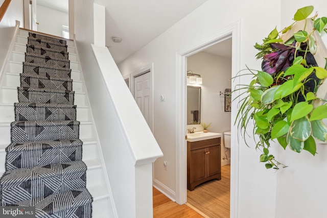 stairway with baseboards and wood finished floors