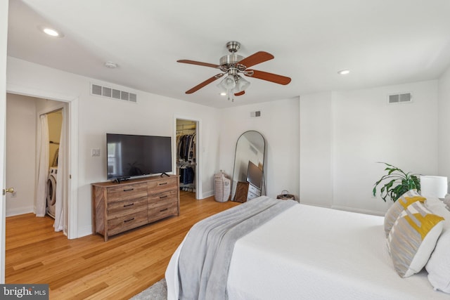bedroom featuring washer / clothes dryer, visible vents, and a walk in closet