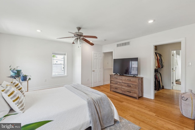 bedroom with ceiling fan, visible vents, a spacious closet, light wood-style floors, and recessed lighting