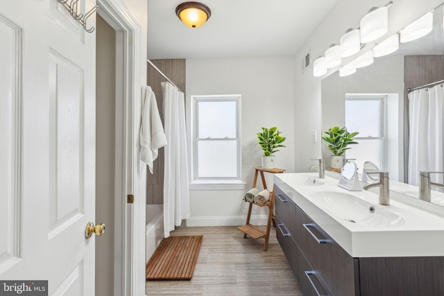 bathroom featuring a sink, plenty of natural light, double vanity, and visible vents